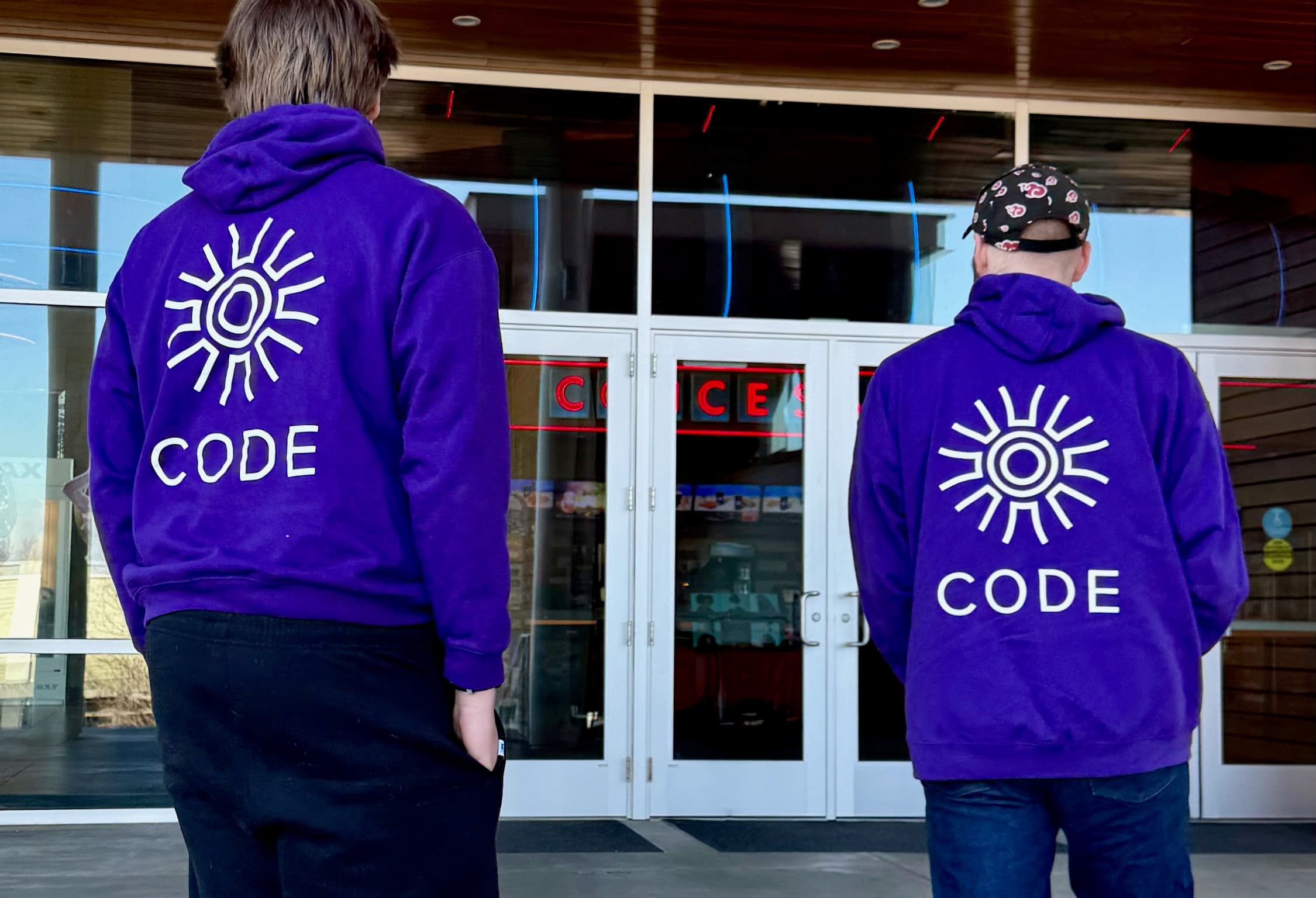 Two people in CODE hoodies
